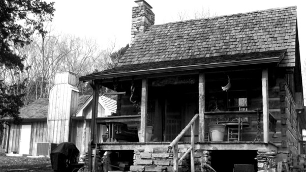 The Cash Cabin exterior — hand-hewn log walls at the edge of a Tennessee lake