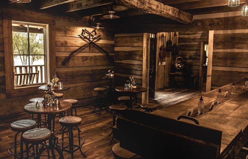 Tasting room bar in reclaimed timber and dark board walls