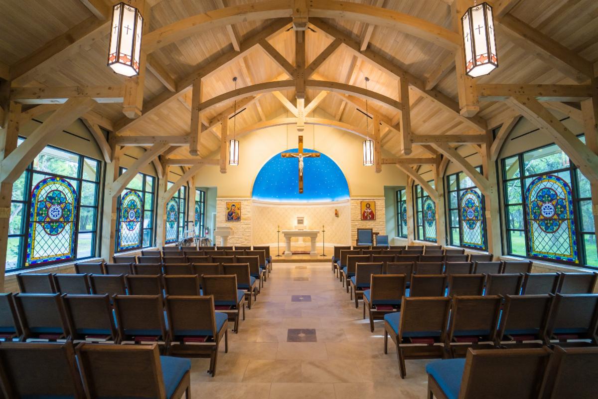 Chapel entry porch framed in heavy timber posts and curved knee braces
