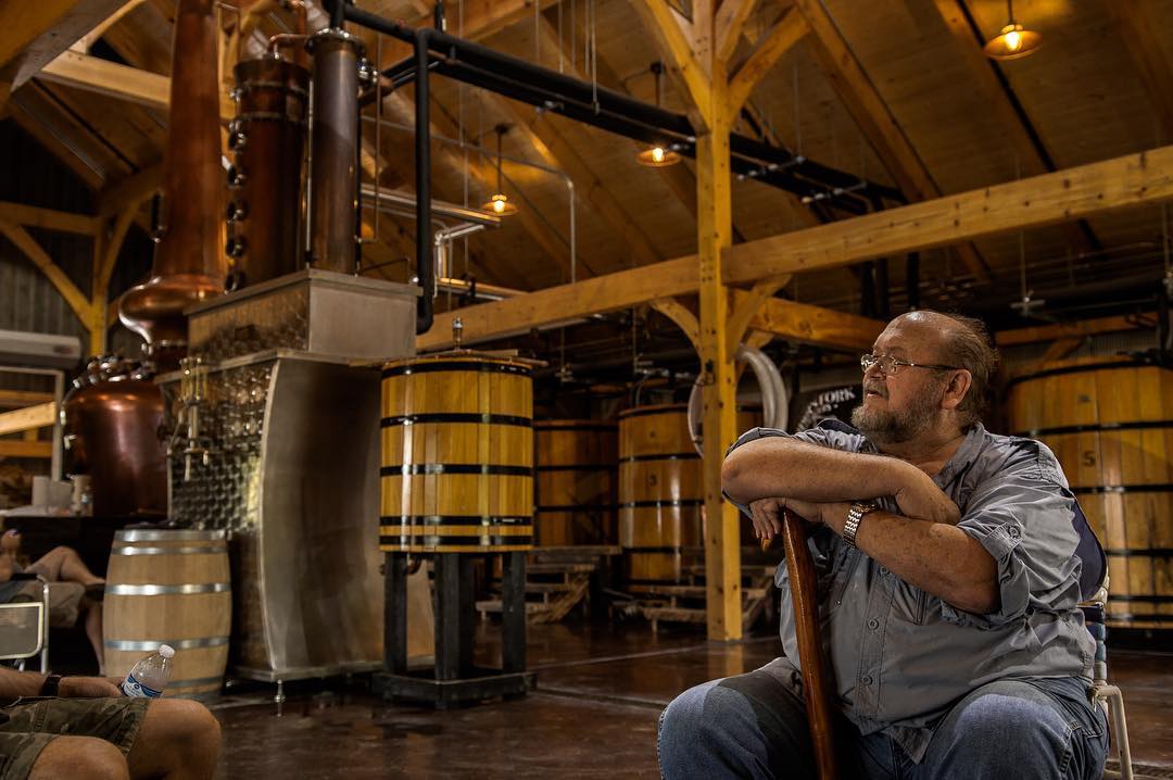 Distiller at rest beside the fermenters in the timber frame stillhouse